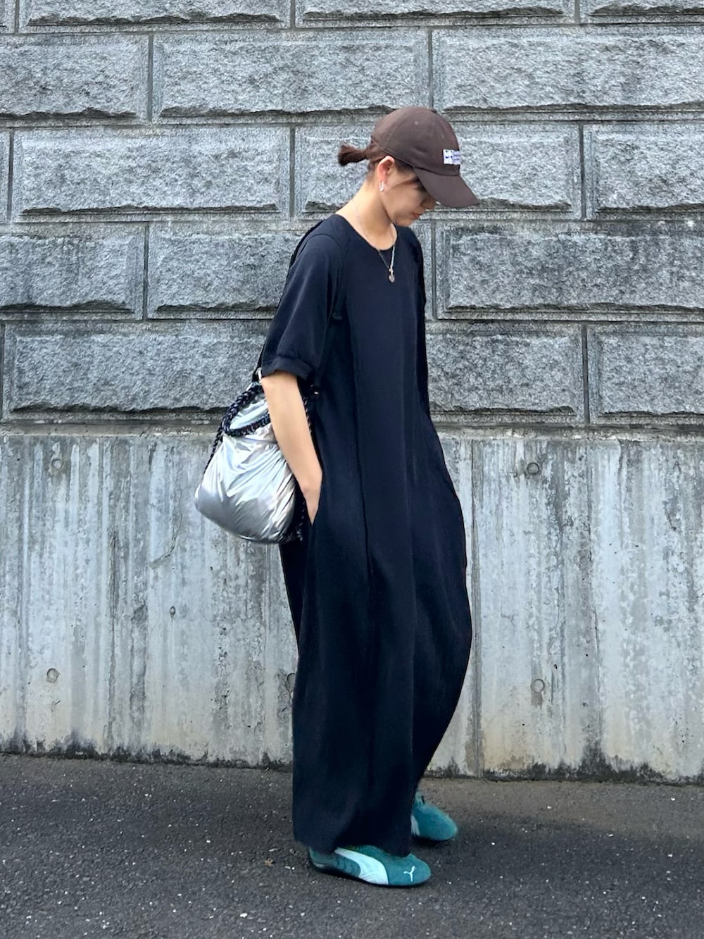ブラック系のワンピース、シルバー系のトートバッグ、グリーン系のスニーカーを着用したレディースの夏コーディネートの3枚目の写真