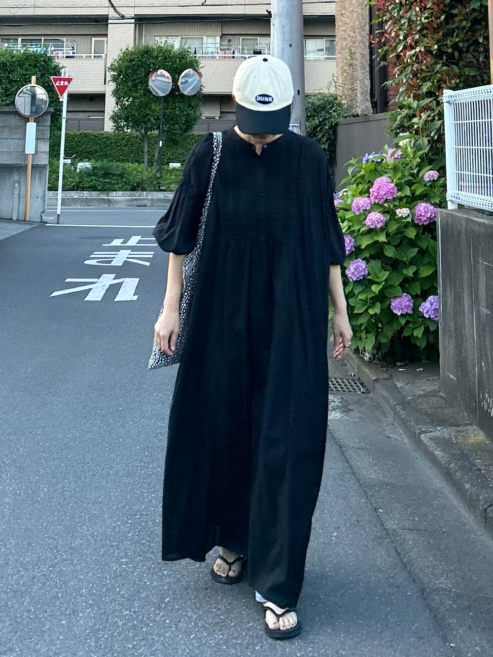ブラック系のワンピース、ブラック系のキャップを着用したレディースの夏コーディネートの2枚目の写真