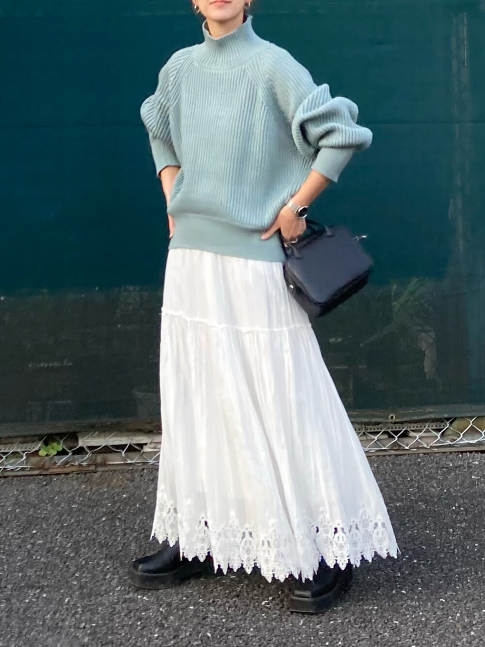 ブルー系のニット/セーター、ブラック系のボストンバッグを着用したレディースの秋コーディネートの4枚目の写真