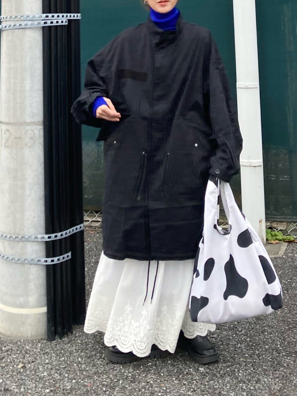 ブラック系のモッズコート、ブルー系のニット/セーター、その他のスニーカーを着用したレディースの冬コーディネートの4枚目の写真