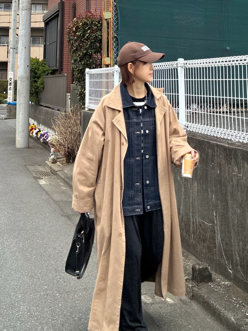 ブルー系のデニムジャケット、ブラック系のスラックス、ブラック系のショルダーバッグを着用したレディースの春コーディネートの3枚目の写真