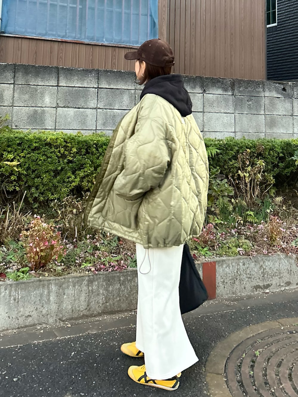 ブラック系のパーカー、ホワイト系のスカート、ブラック系のトートバッグを着用したレディースの冬コーディネートの5枚目の写真