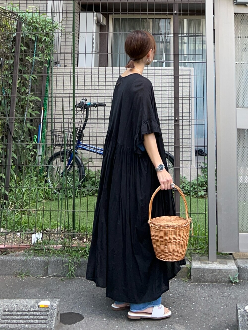 ブラック系のワンピース、ブルー系のデニムパンツ、ホワイト系のサンダルを着用したレディースの夏コーディネートの4枚目の写真