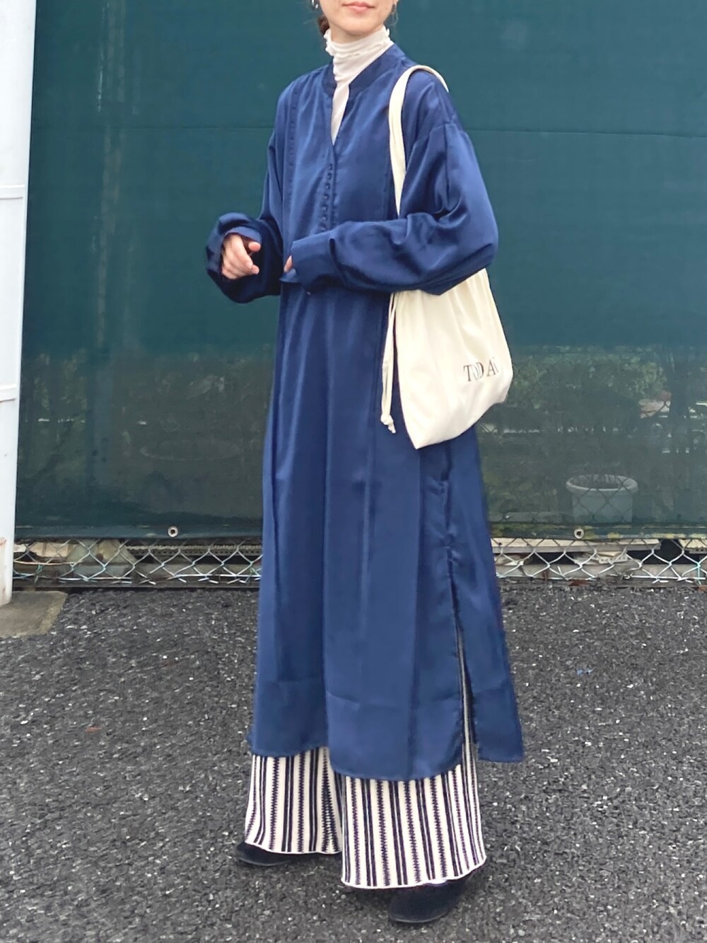 ブルー系のシャツワンピース、ブラック系のその他パンツ、ホワイト系のトートバッグを着用したレディースの秋コーディネートの4枚目の写真