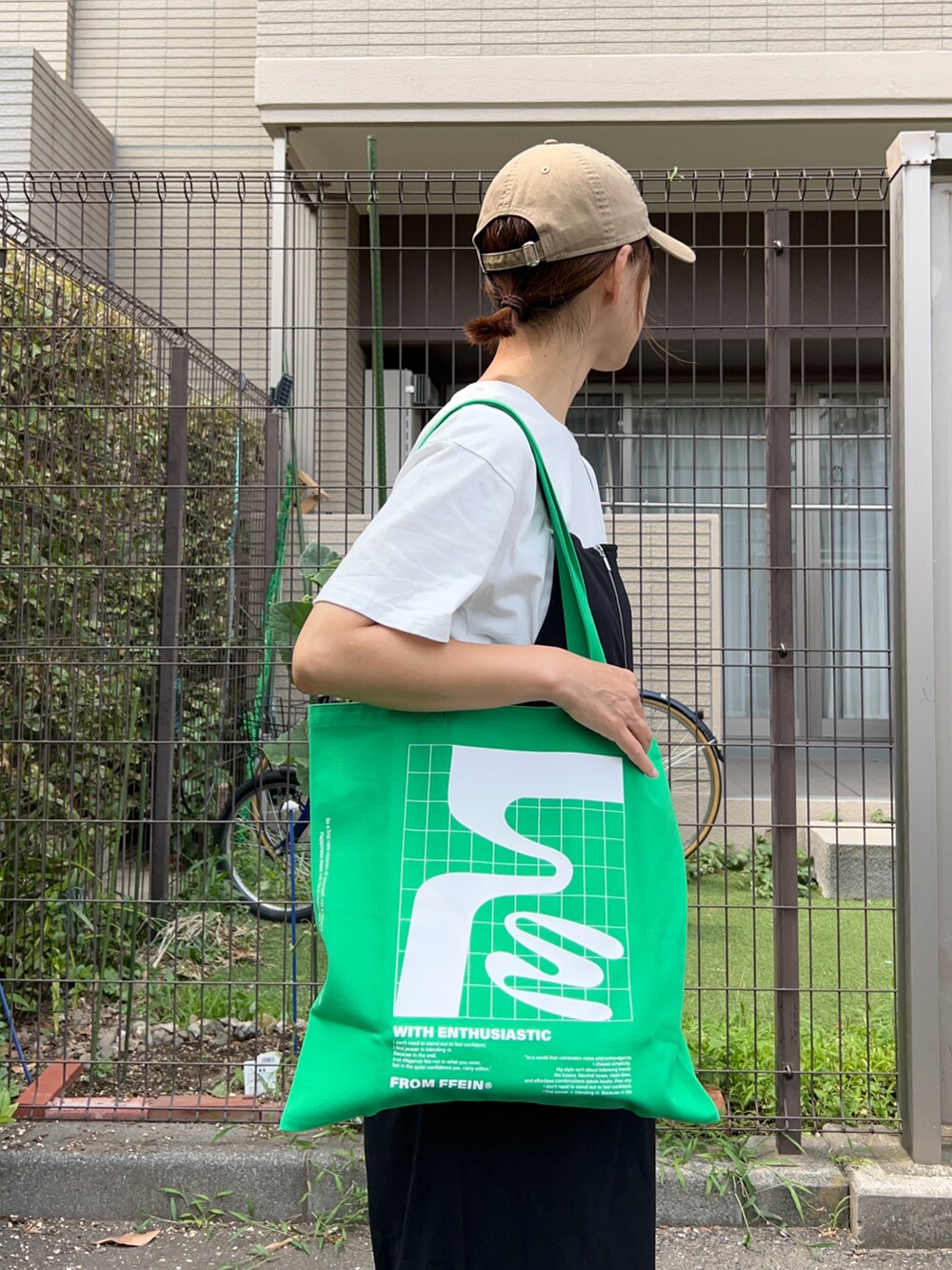 ホワイト系のTシャツ/カットソー、ブラック系のワンピース、グリーン系のバッグを着用したレディースの夏コーディネートの5枚目の写真