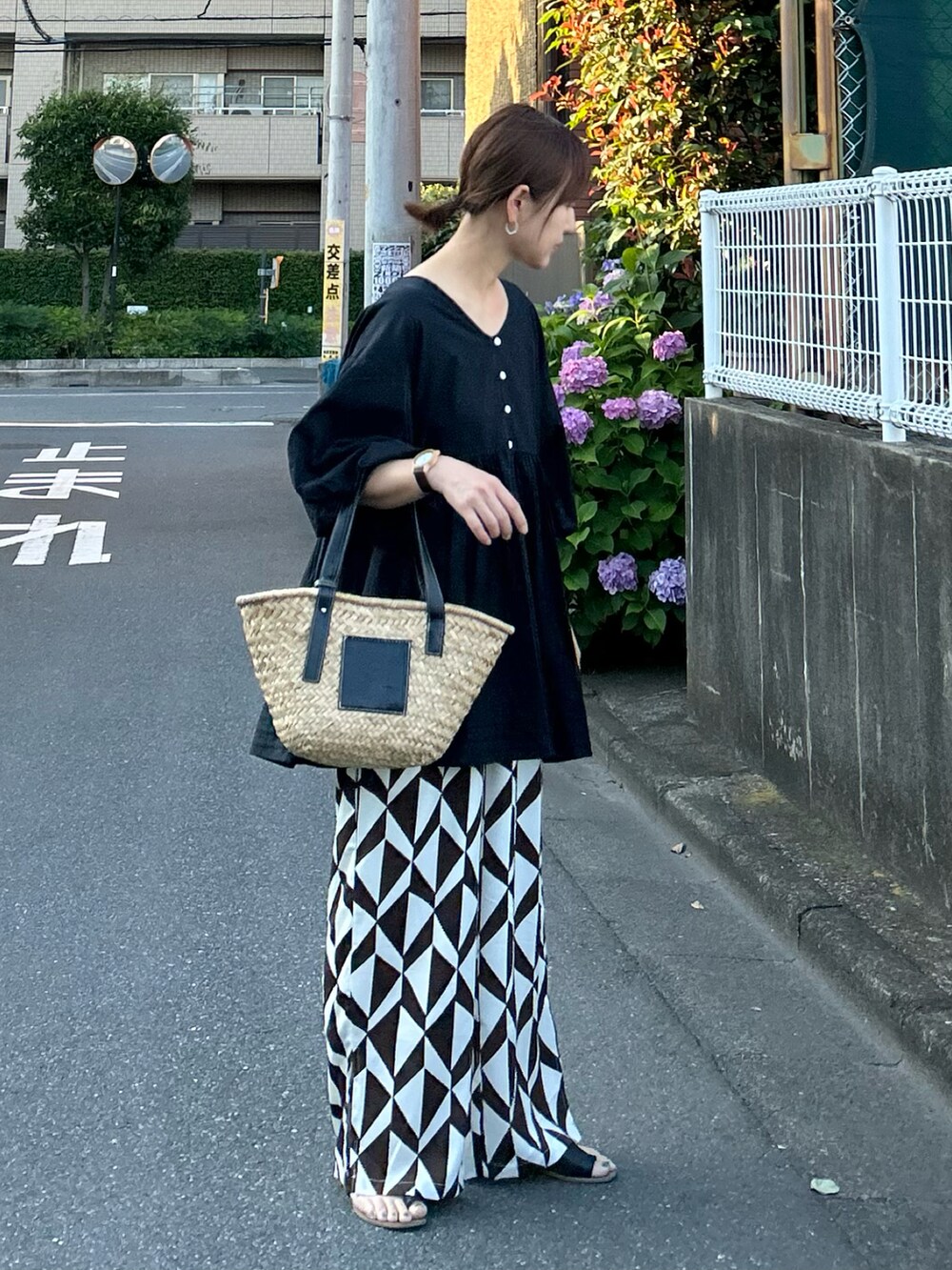 ブラック系のチュニック、ブラウン系のその他パンツ、ブラック系のかごバッグを着用したレディースの夏コーディネートの4枚目の写真