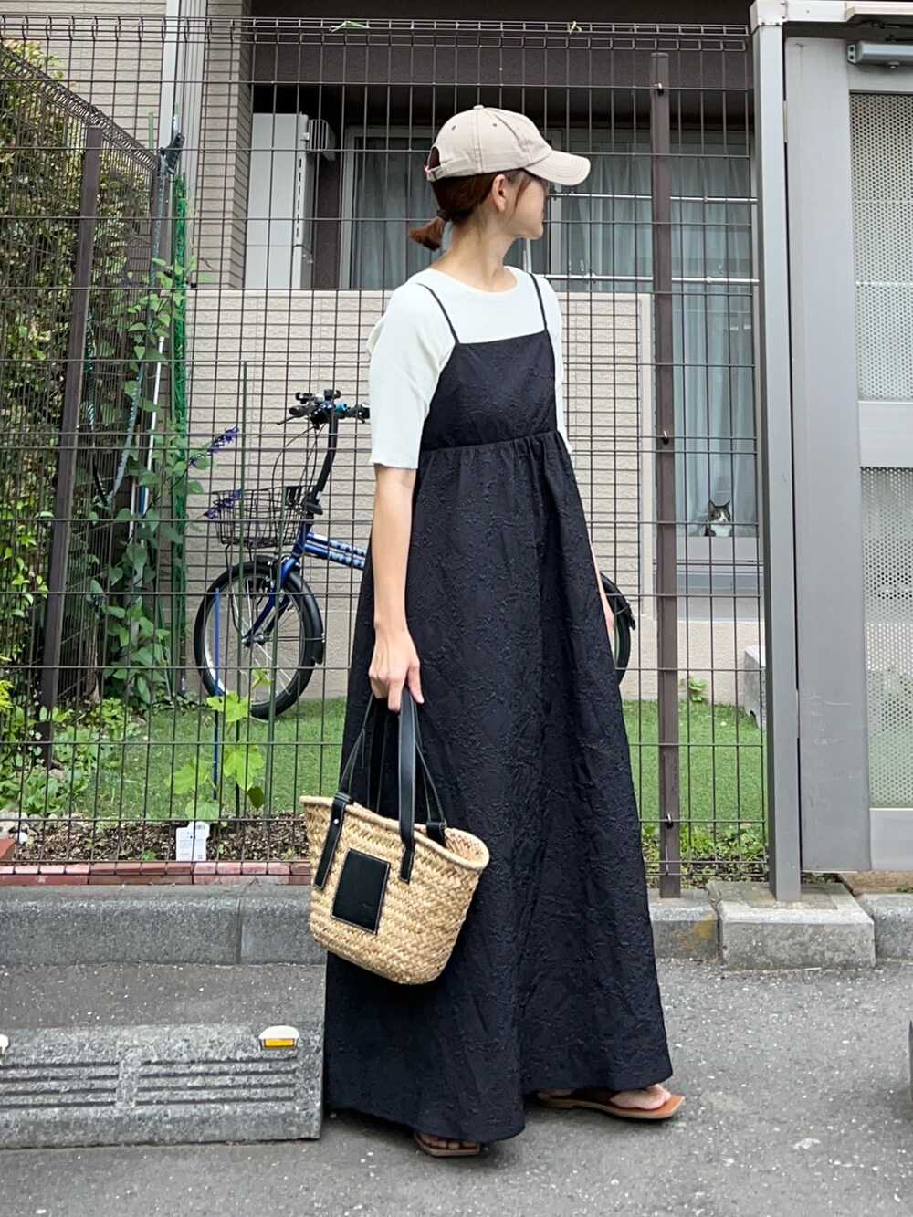 ホワイト系のTシャツ/カットソー、ブラック系のワンピース、ブラック系のかごバッグを着用したレディースの夏コーディネートの3枚目の写真