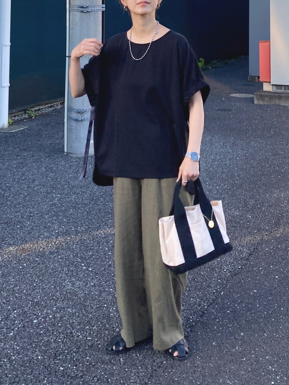 ブラック系のTシャツ/カットソー、グリーン系のその他パンツ、ホワイト系のトートバッグを着用したレディースの夏コーディネートの2枚目の写真
