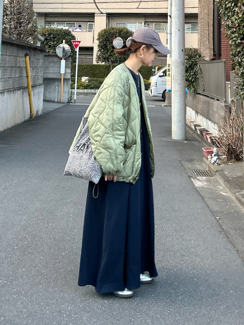 ブルー系のワンピース、グリーン系のノーカラージャケット、シルバー系のスニーカーを着用したレディースの冬コーディネートの2枚目の写真
