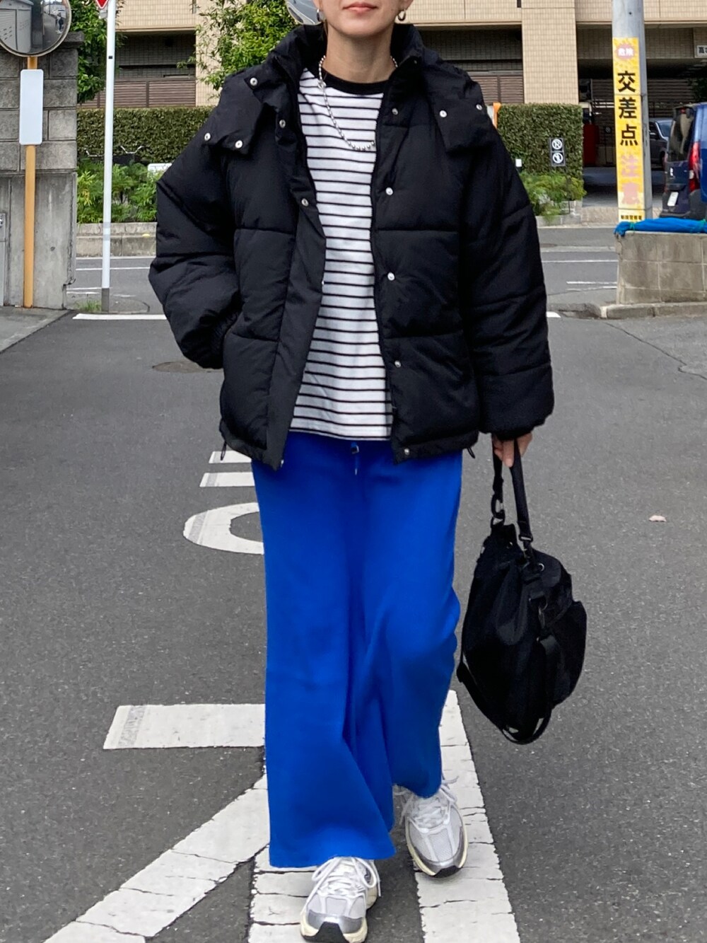 ブラック系のダウンジャケット/コート、ブラック系のTシャツ/カットソー、ブルー系のスカートを着用したレディースの秋コーディネートの4枚目の写真