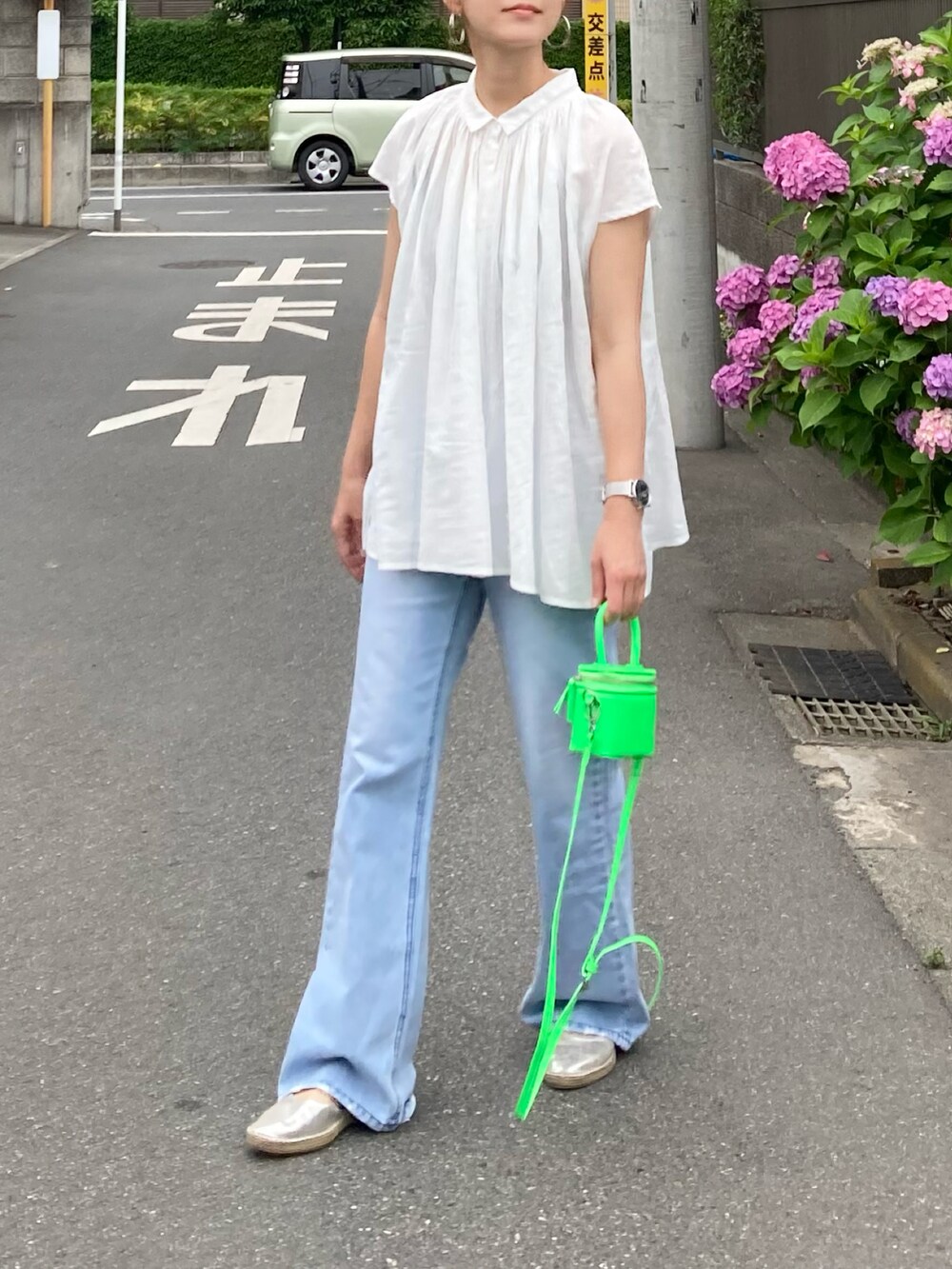 ホワイト系のシャツ/ブラウス、ブルー系のデニムパンツ、グリーン系のショルダーバッグを着用したレディースの夏コーディネートの2枚目の写真