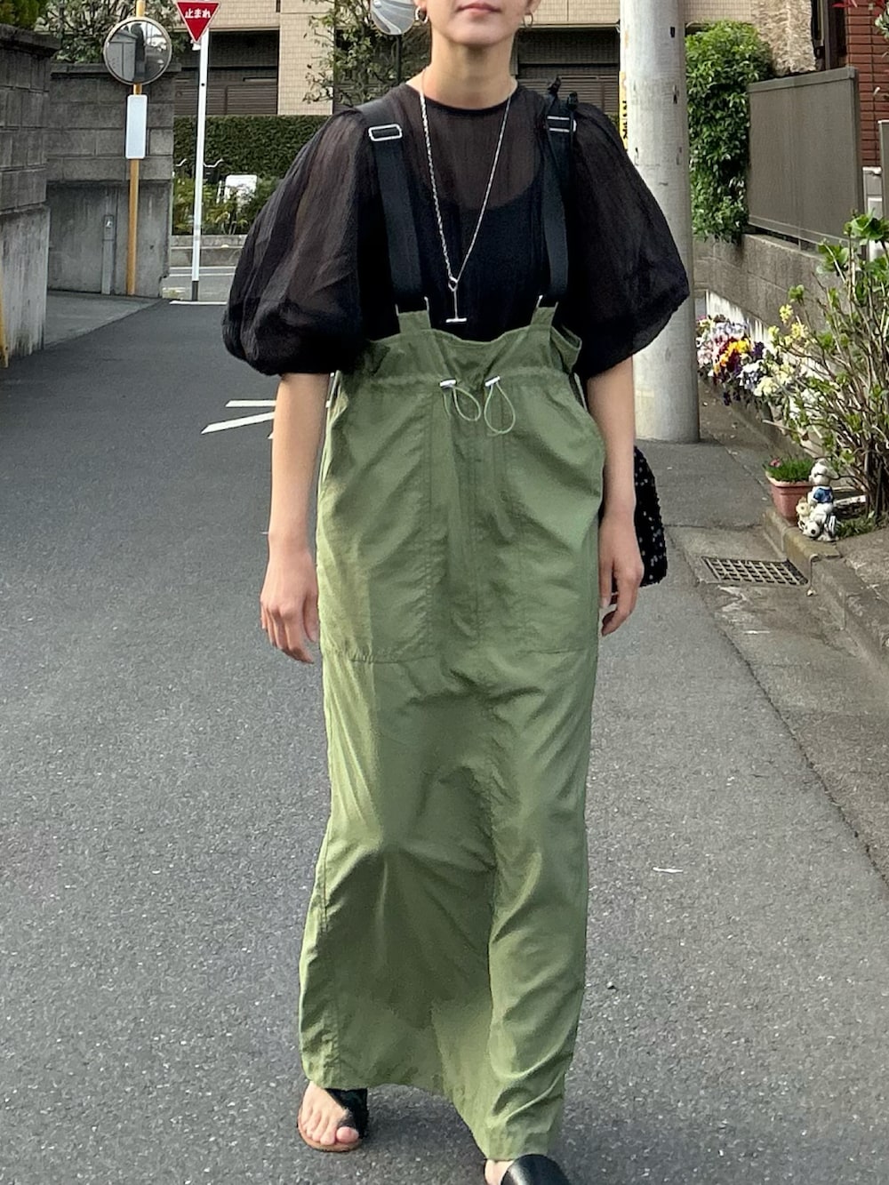 グリーン系のジャンパースカート、ブラック系のシャツ/ブラウス、ブラック系のショルダーバッグを着用したレディースの春コーディネートの4枚目の写真