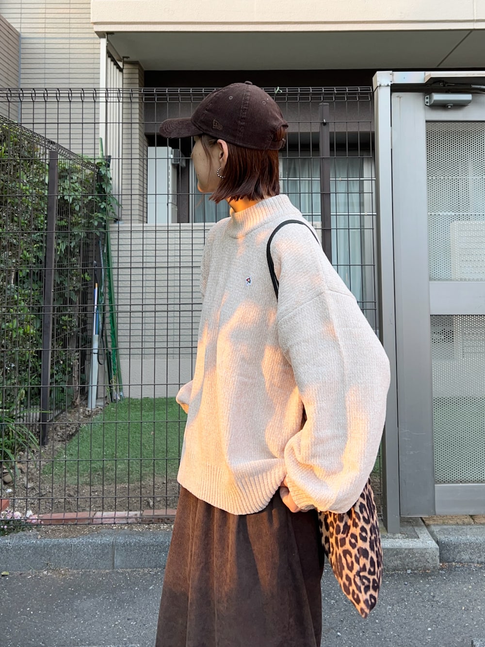 ベージュ系のニット/セーター、ブラウン系のスラックス、ブラウン系のトートバッグを着用したレディースの秋コーディネートの3枚目の写真