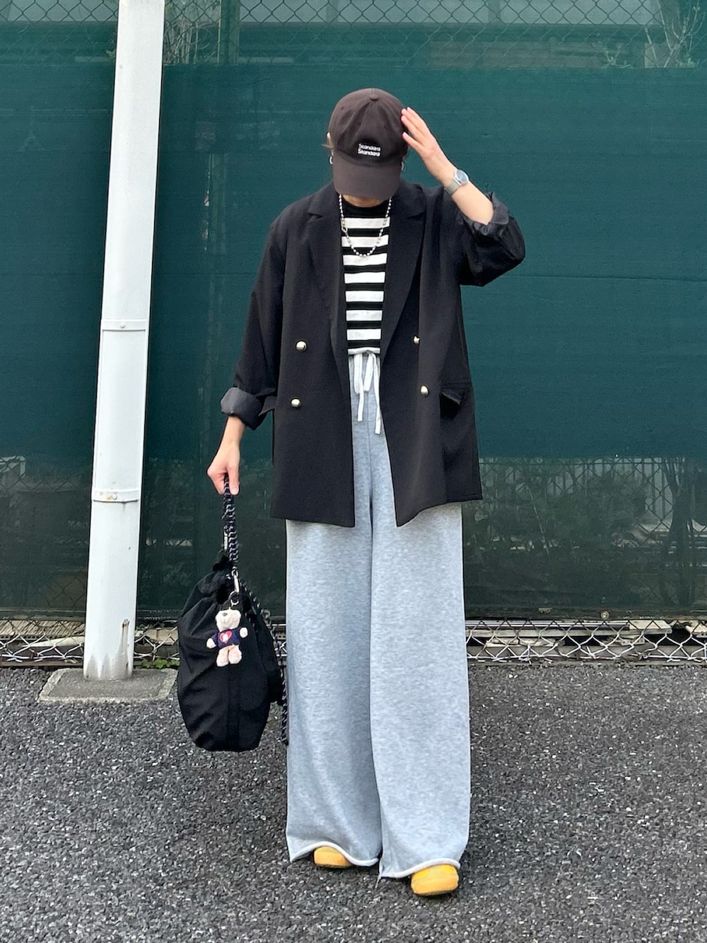 ブラック系のTシャツ/カットソー、ブラック系のテーラードジャケット、ブラック系のトートバッグを着用したレディースの春コーディネートの2枚目の写真