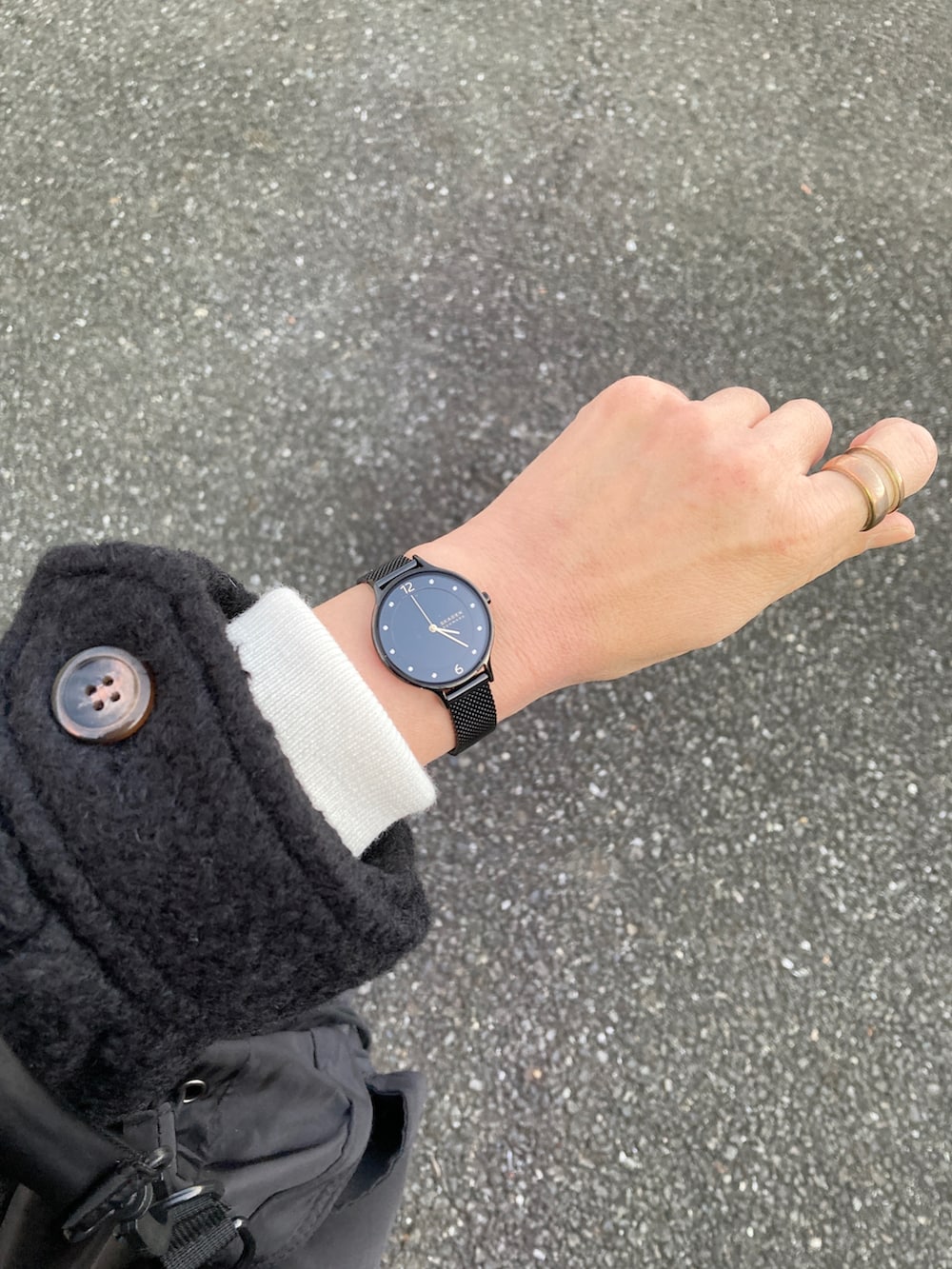 ブラック系のダッフルコート、ホワイト系のニット/セーター、ブラック系のショルダーバッグを着用したレディースの冬コーディネートの2枚目の写真