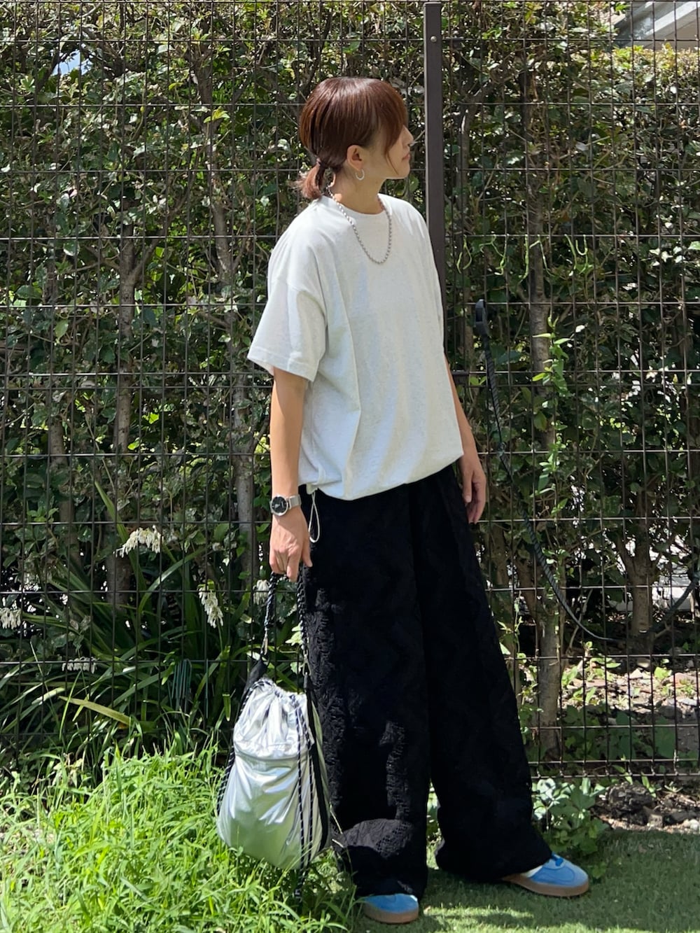 グレー系のTシャツ/カットソー、ブラック系のその他パンツ、グリーン系のトートバッグを着用したレディースの秋コーディネートの3枚目の写真