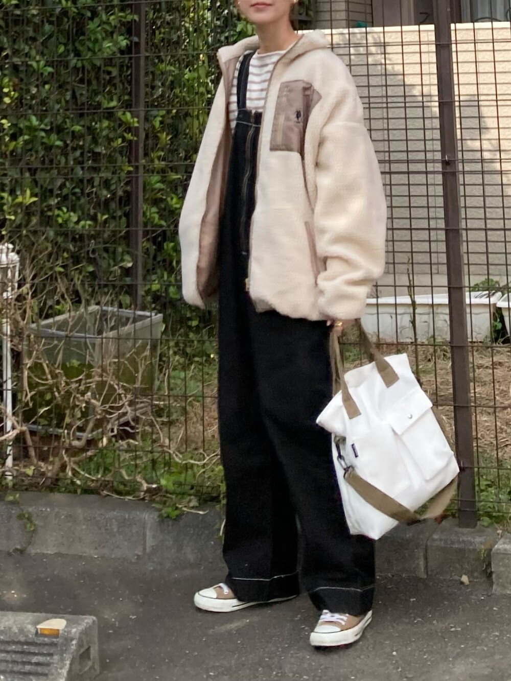 ベージュ系のブルゾン、ベージュ系のTシャツ/カットソー、ブラック系のサロペット/オーバーオールを着用したレディースの秋コーディネートの5枚目の写真