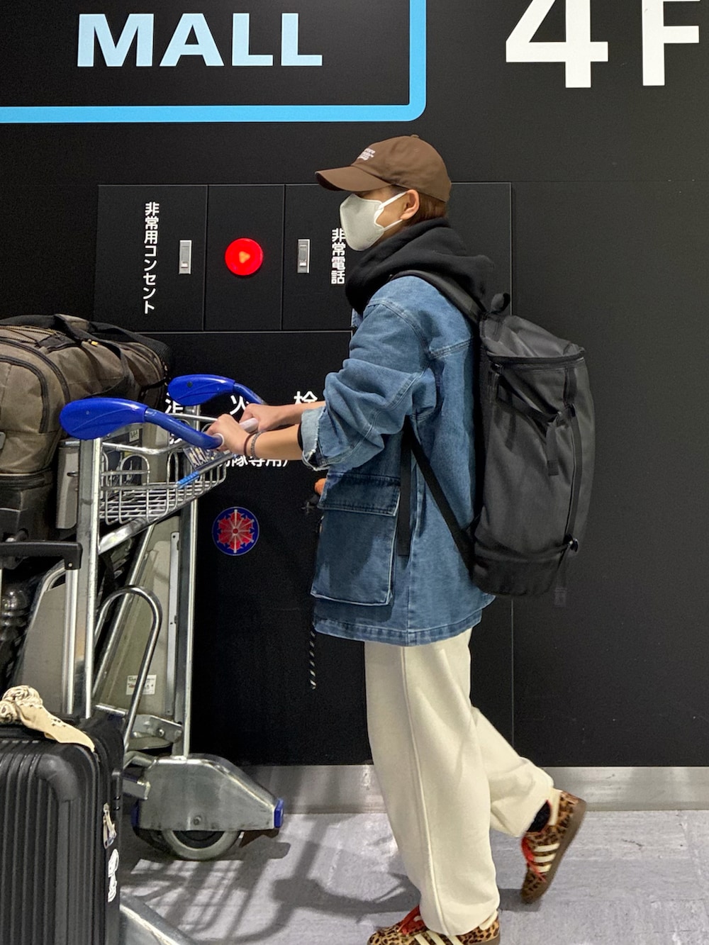 ブルー系のデニムジャケット、ブラック系のパーカー、オレンジ系のショルダーバッグを着用したレディースの春コーディネートの3枚目の写真