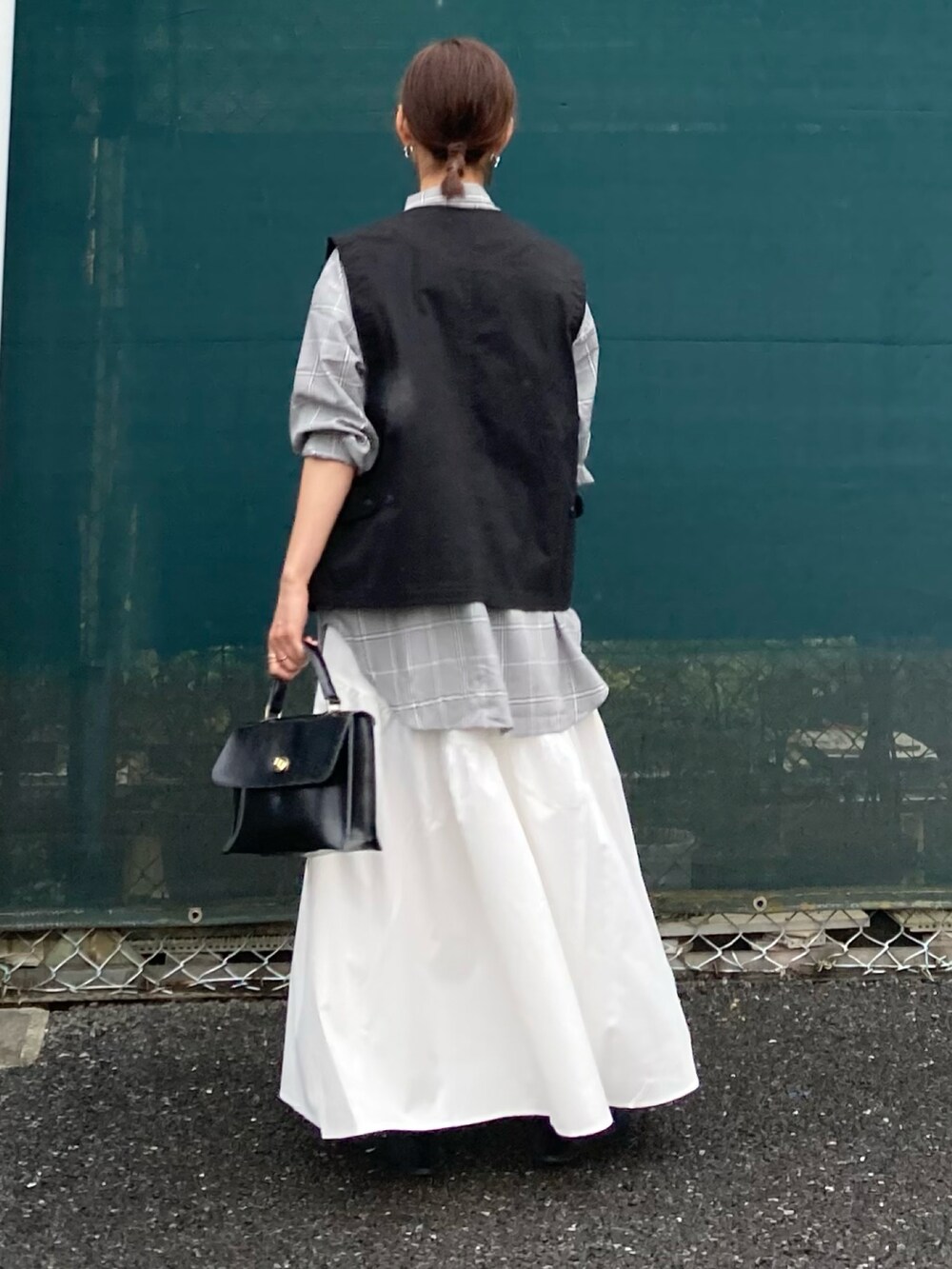 ブラック系のベスト、ホワイト系のスカート、ブラウン系のシャツ/ブラウスを着用したレディースの夏コーディネートの5枚目の写真