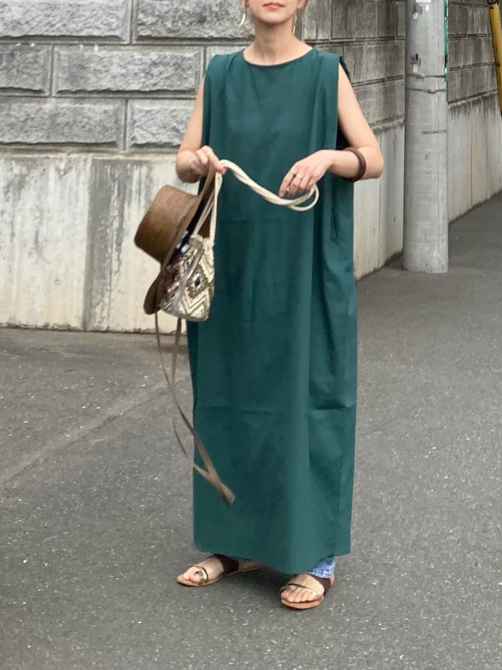グリーン系のワンピース、その他のショルダーバッグ、ブラウン系のサンダルを着用したレディースの春コーディネートの2枚目の写真