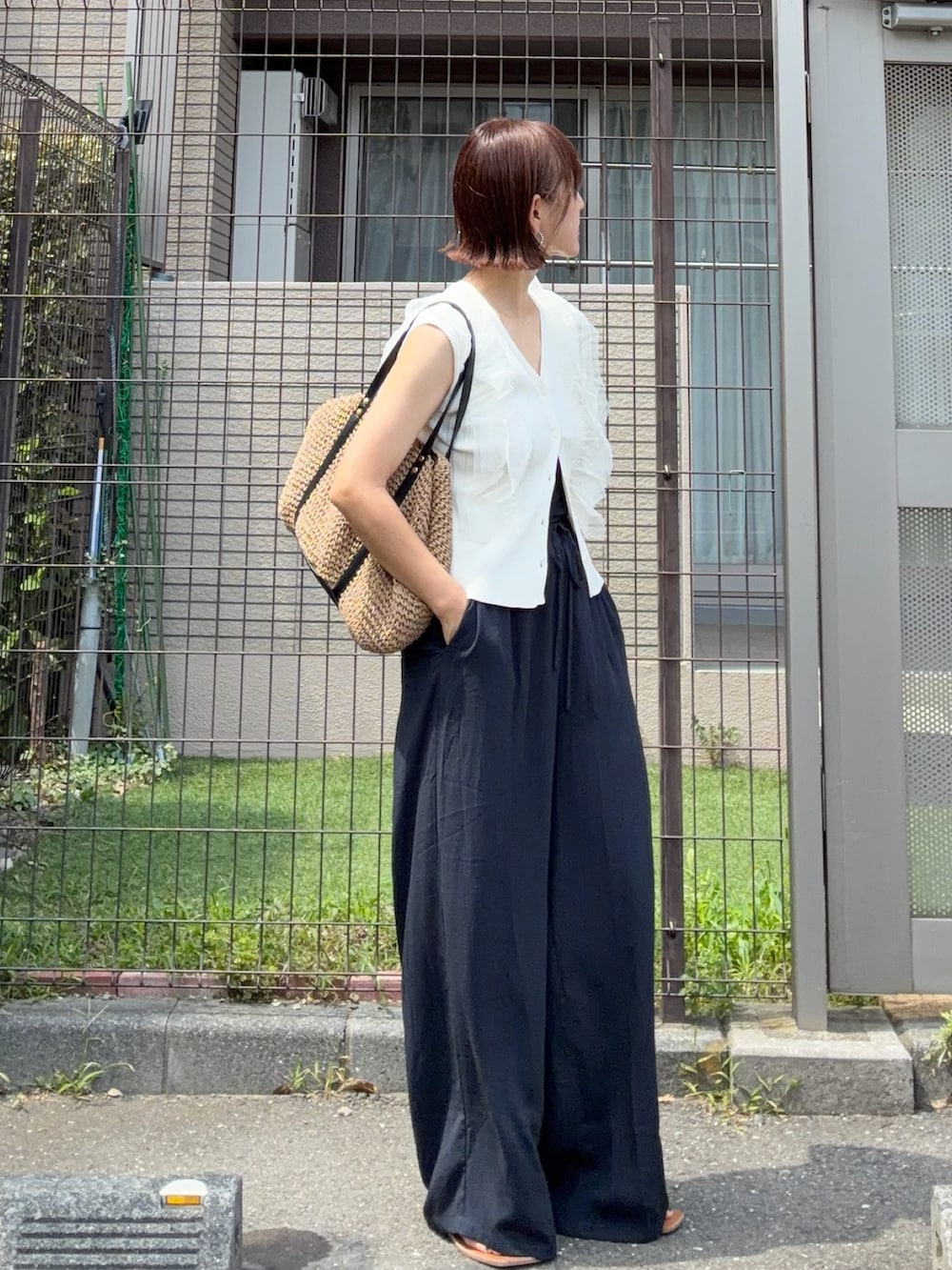ホワイト系のカーディガン/ボレロ、イエロー系のトートバッグ、ブルー系のスラックスを着用したレディースの夏コーディネートの2枚目の写真