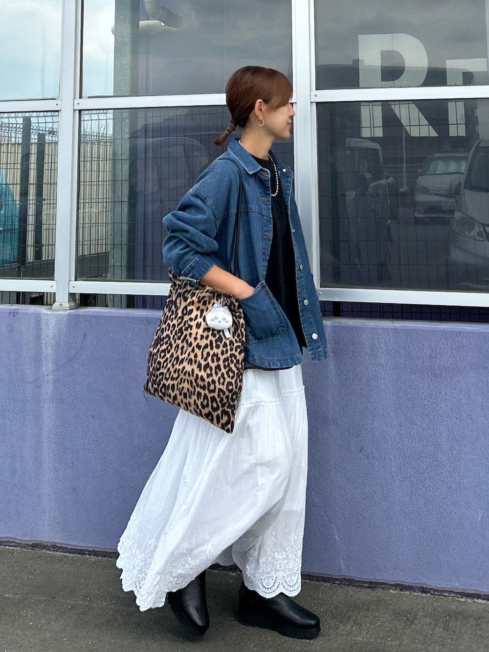ホワイト系のスカート、ブルー系のデニムジャケット、ブラウン系のトートバッグを着用したレディースの秋コーディネートの4枚目の写真