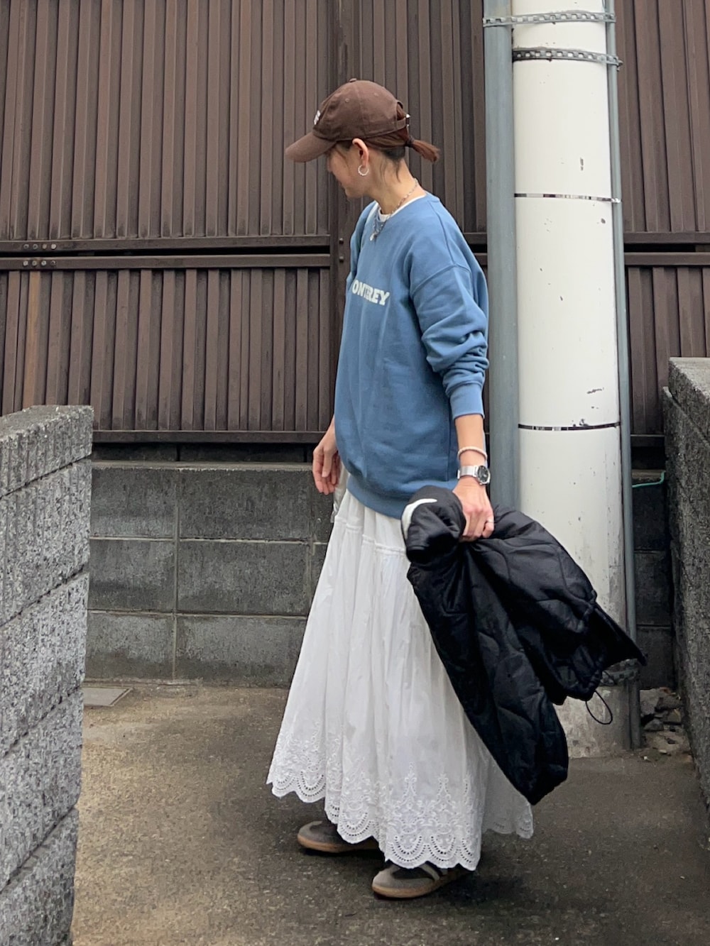 ブルー系のスウェット、ホワイト系のスカート、ブラック系のブルゾンを着用したレディースの冬コーディネートの5枚目の写真