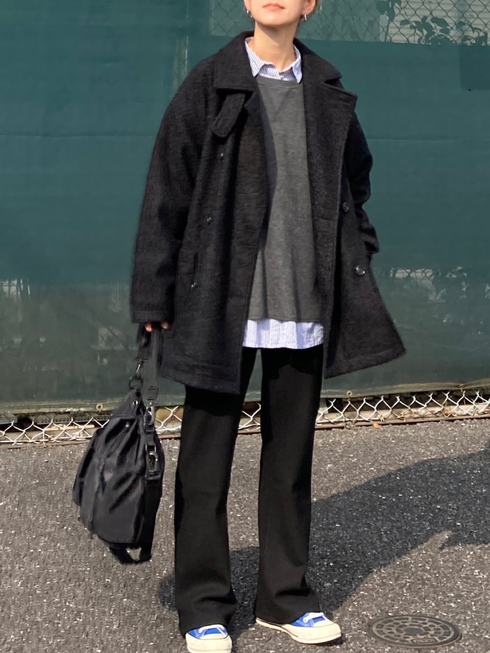 ブラック系のピーコート、グレー系のニット/セーター、ブルー系のシャツ/ブラウスを着用したレディースの秋コーディネートの3枚目の写真