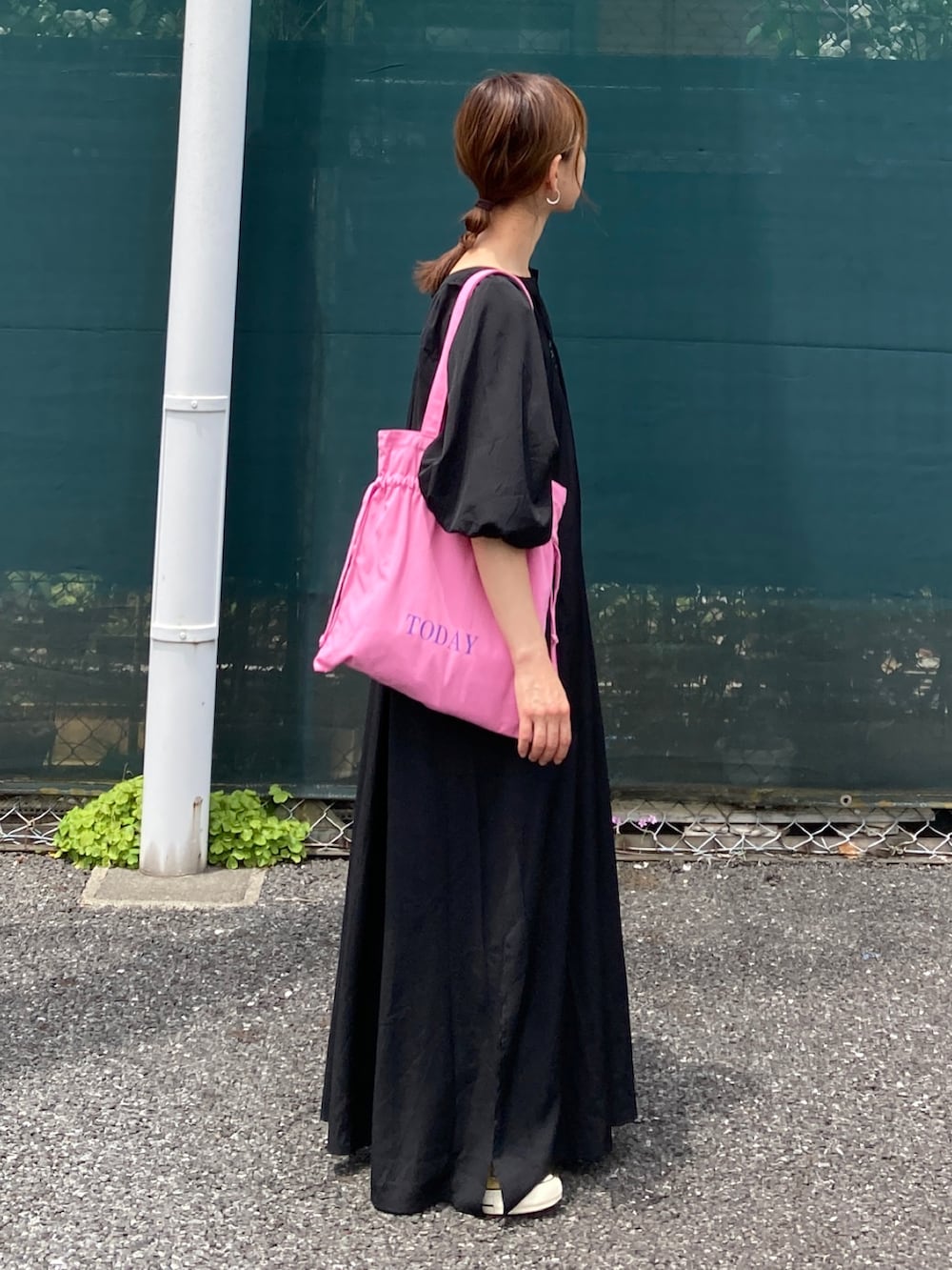 ブラック系のワンピース、ピンク系のトートバッグを着用したレディースの夏コーディネートの2枚目の写真