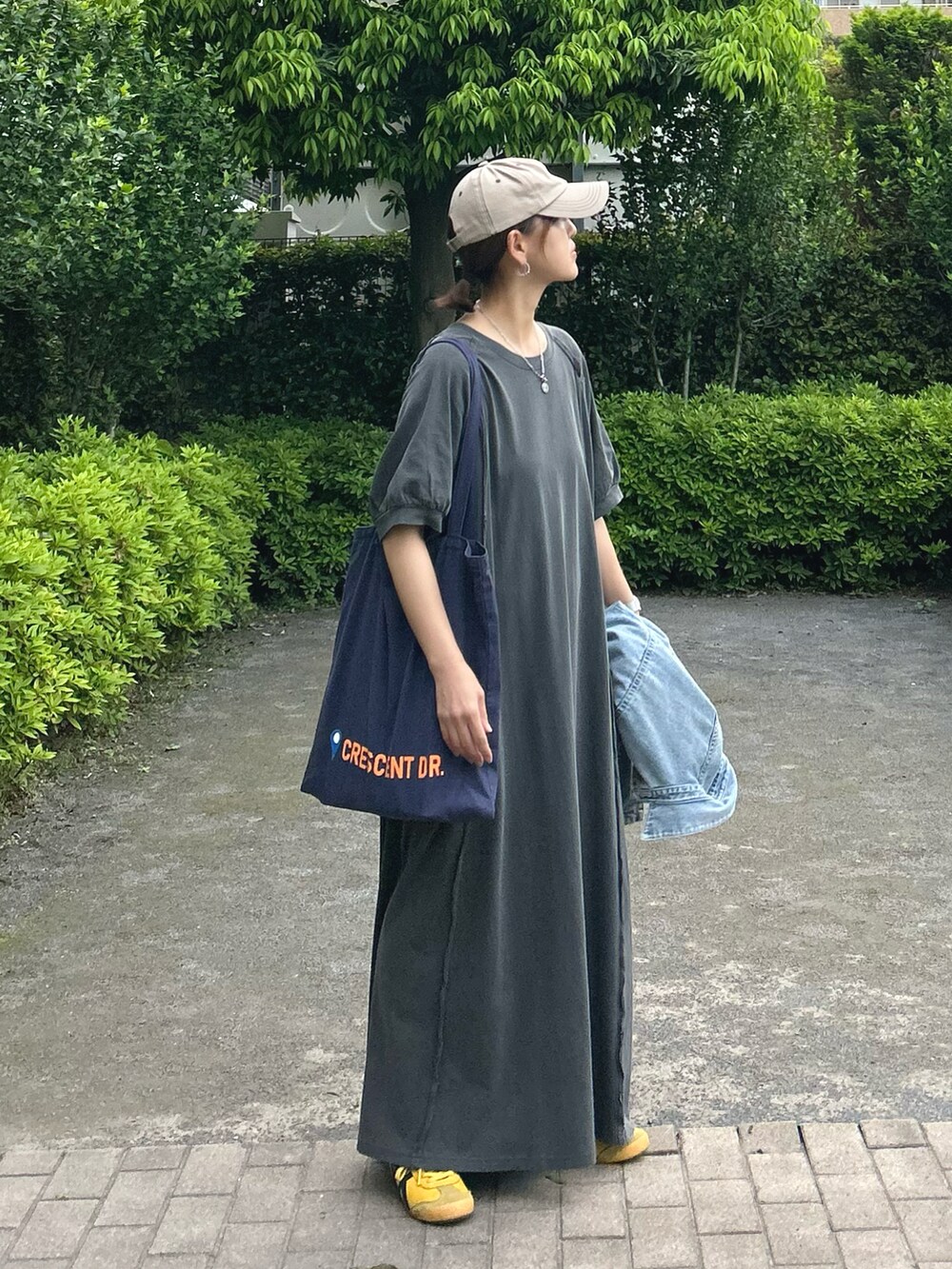 グレー系のワンピース、ブルー系のトートバッグを着用したレディースの春コーディネートの2枚目の写真