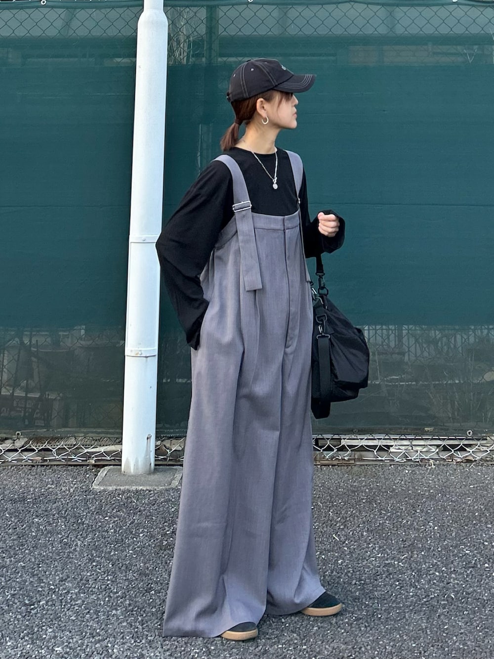グレー系のサロペット/オーバーオール、ブラック系のショルダーバッグ、ブラック系のキャップを着用したレディースの春コーディネートの2枚目の写真