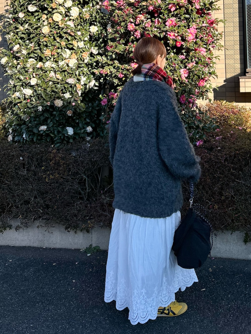 グレー系のTシャツ/カットソー、ホワイト系のスカート、グレー系のカーディガン/ボレロを着用したレディースの冬コーディネートの5枚目の写真