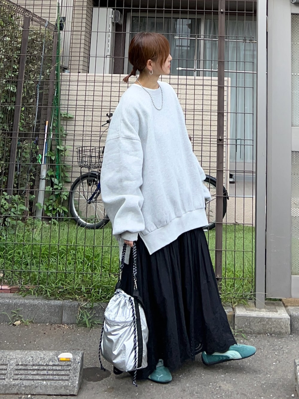 グレー系のスウェット、シルバー系のトートバッグ、ブラック系のスカートを着用したレディースの冬コーディネートの4枚目の写真
