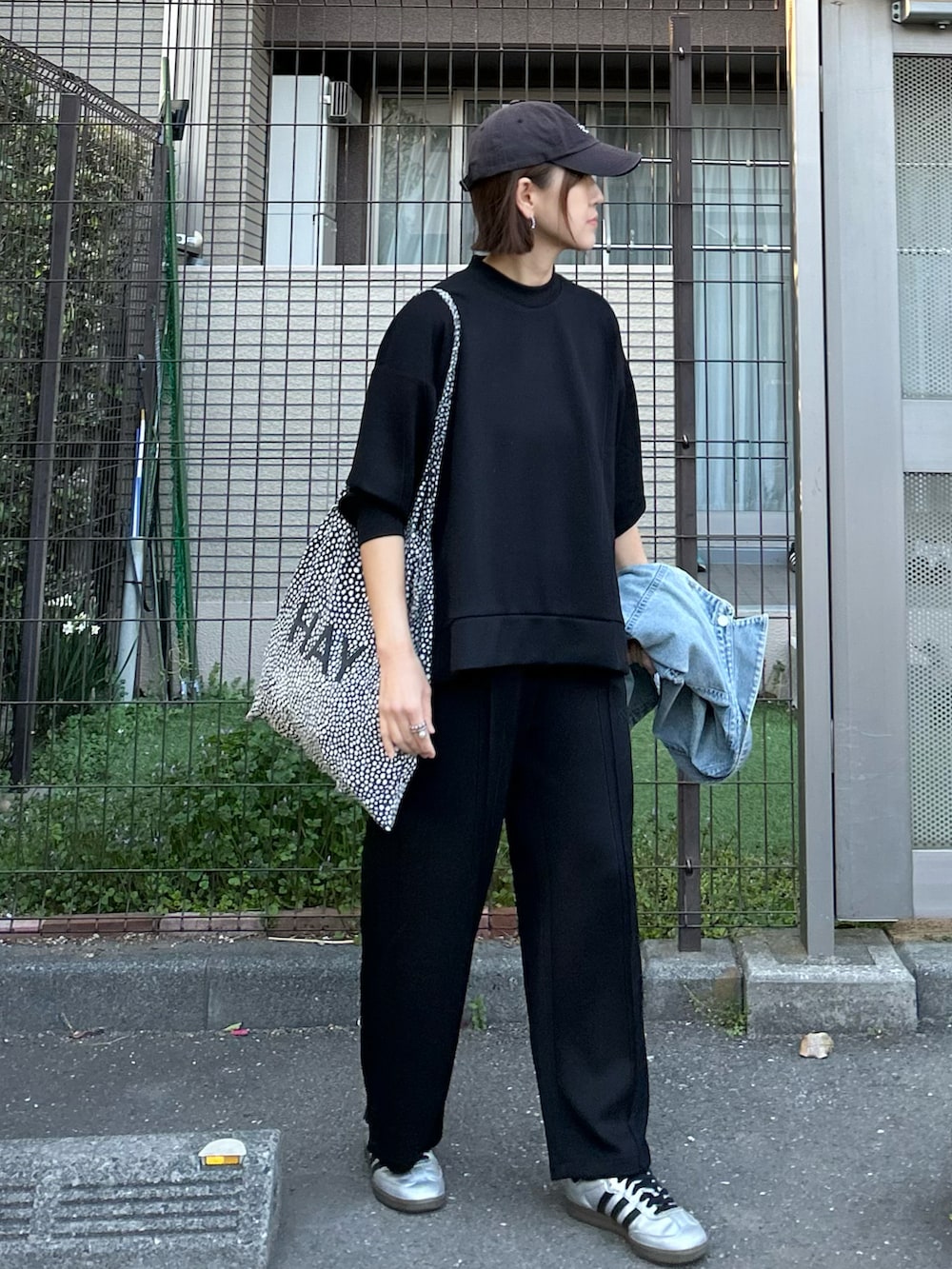 シルバー系のスニーカー、ブラック系のTシャツ/カットソー、ブラック系のその他パンツを着用したレディースの春コーディネートの2枚目の写真