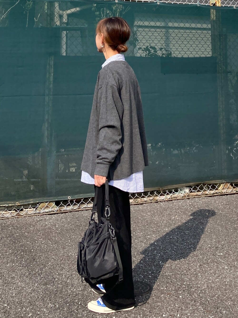 グレー系のニット/セーター、ブルー系のシャツ/ブラウス、ブラック系のその他パンツを着用したレディースの秋コーディネートの4枚目の写真