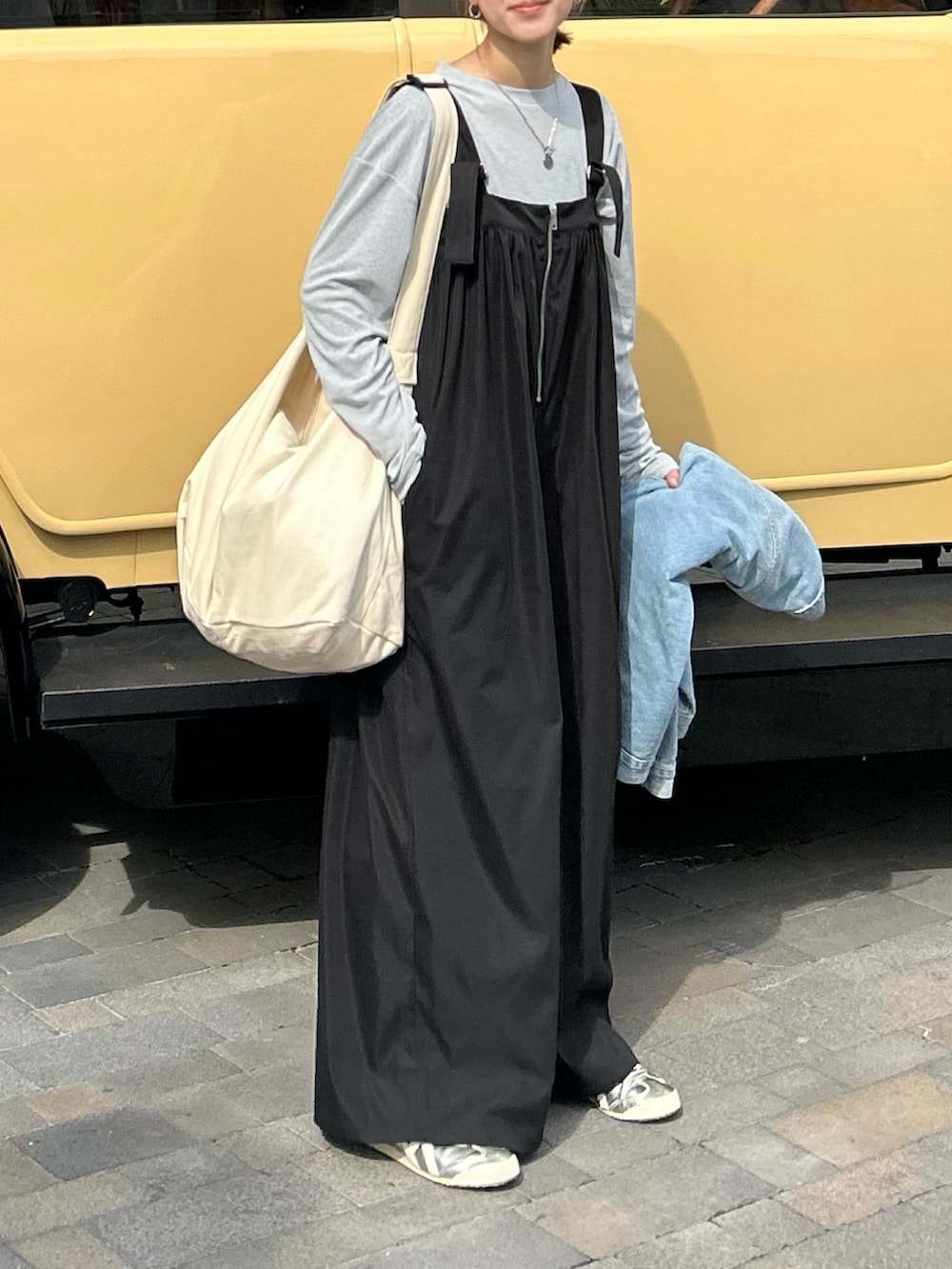 ブルー系のTシャツ/カットソー、ブラック系のサロペット/オーバーオール、ホワイト系のショルダーバッグを着用したレディースの冬コーディネートの3枚目の写真