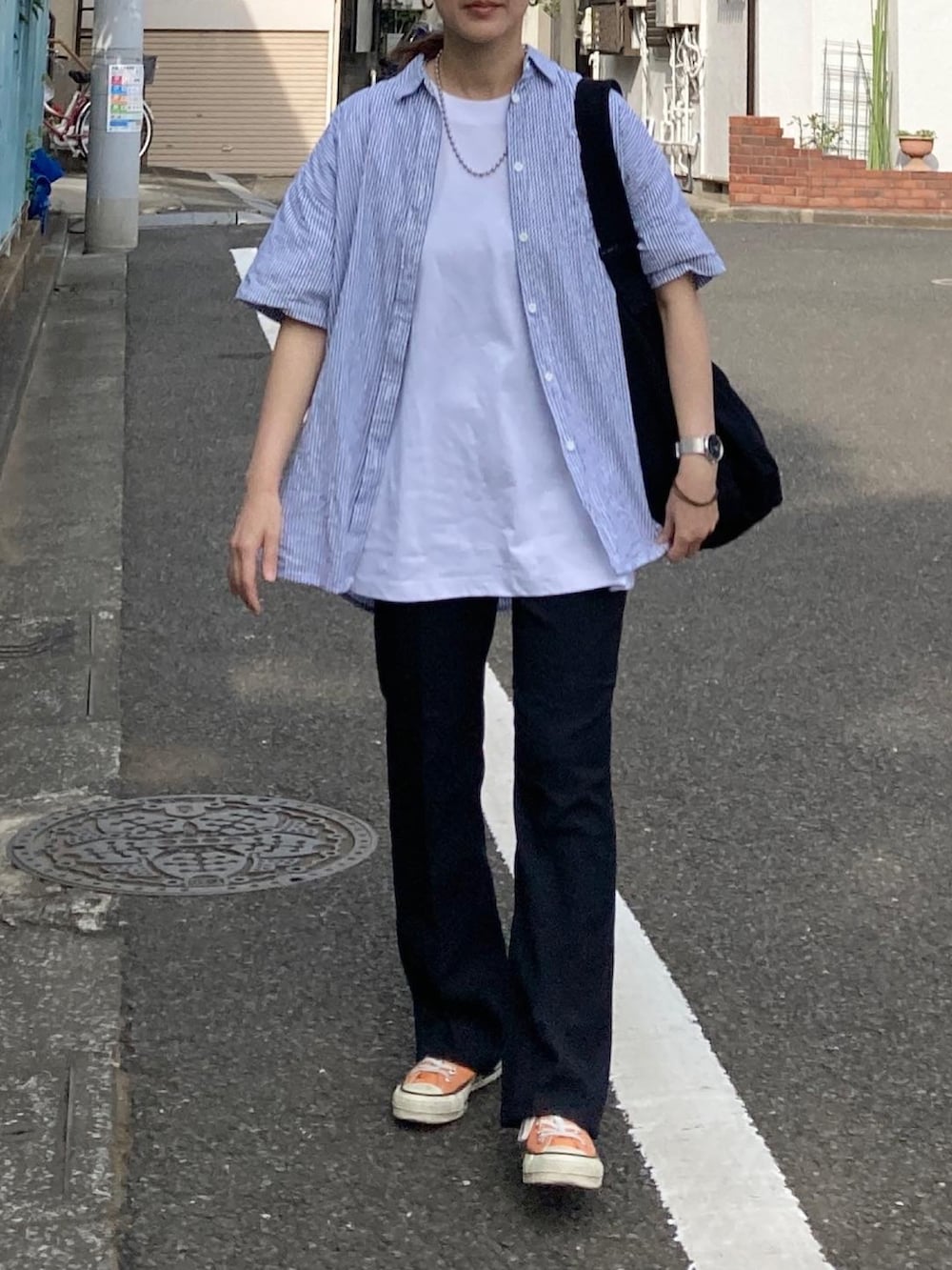 ブルー系のシャツ/ブラウス、ホワイト系のTシャツ/カットソー、ブラック系のショルダーバッグを着用したレディースの春コーディネートの3枚目の写真