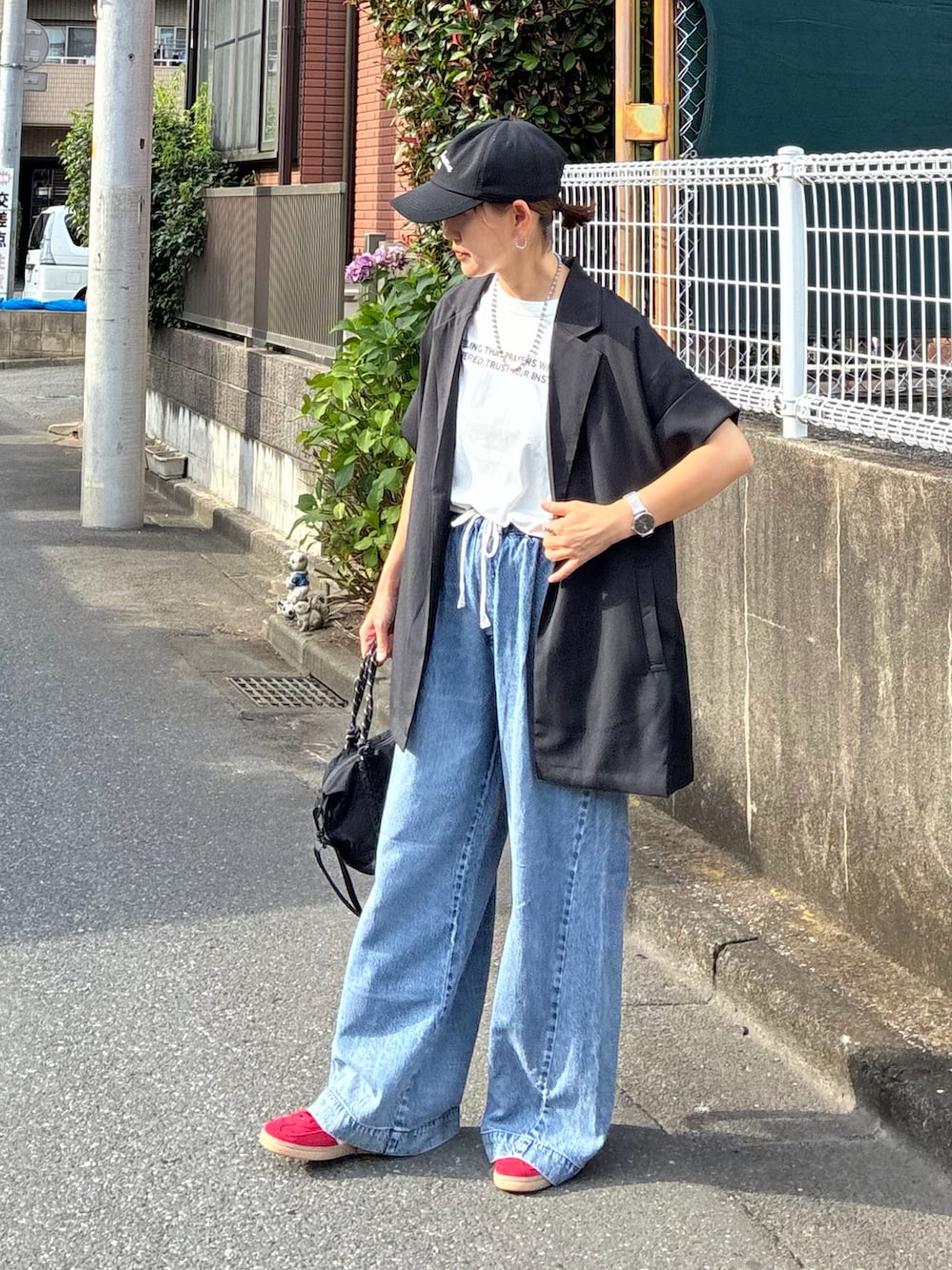 ブラック系のテーラードジャケット、ホワイト系のTシャツ/カットソー、ブラック系のトートバッグを着用したレディースの夏コーディネートの2枚目の写真