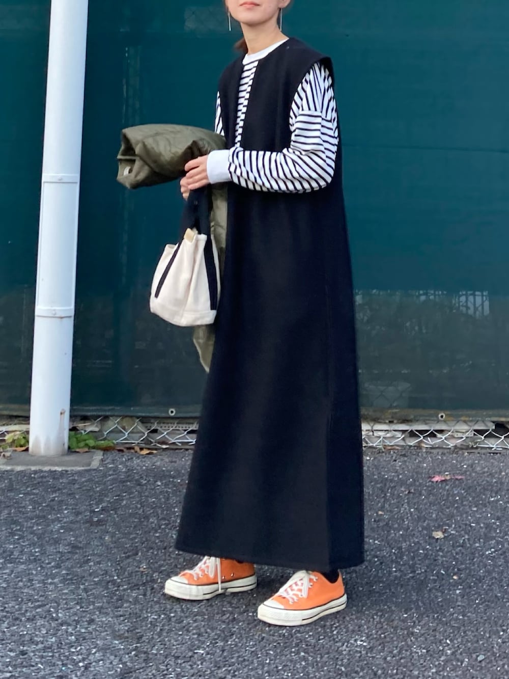 グリーン系のノーカラージャケット、ブラック系のワンピース、ブラック系のTシャツ/カットソーを着用したレディースの冬コーディネートの4枚目の写真