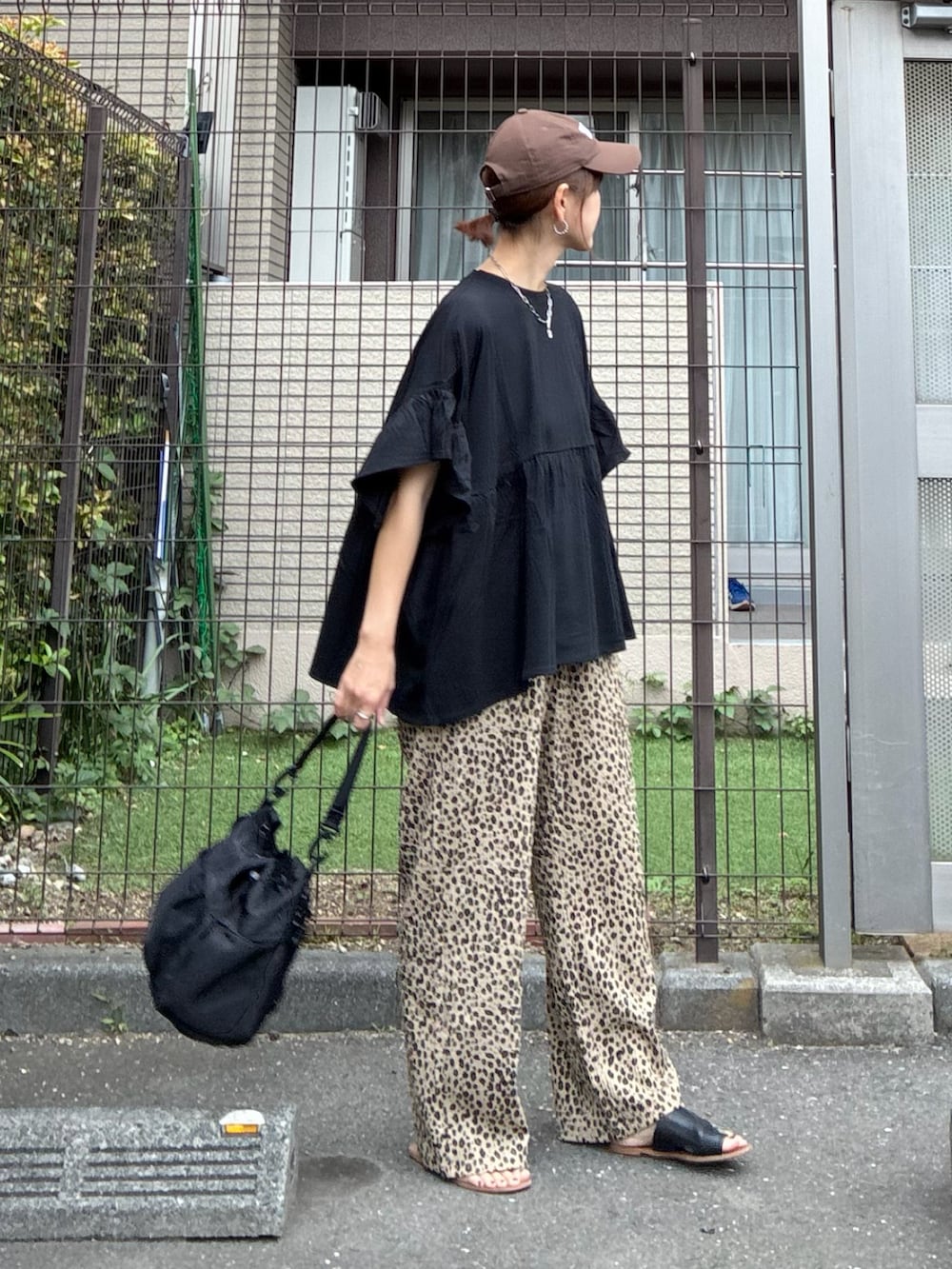 ブラック系のTシャツ/カットソー、ベージュ系のスウェットパンツ、ブラック系のショルダーバッグを着用したレディースの春コーディネートの2枚目の写真