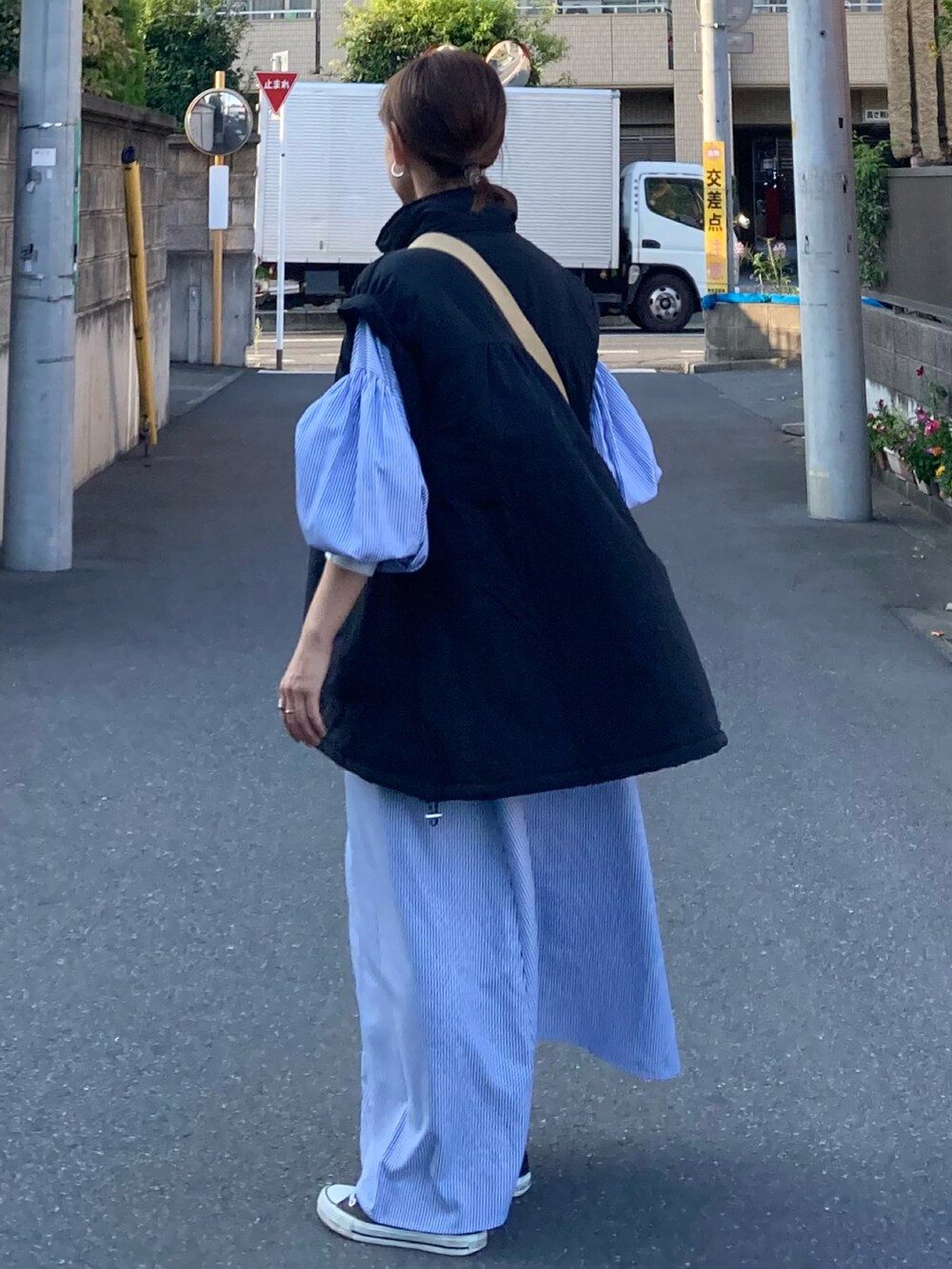 ブラック系のダウンジャケット/コート、ブルー系のワンピース、ベージュ系のショルダーバッグを着用したレディースの秋コーディネートの5枚目の写真