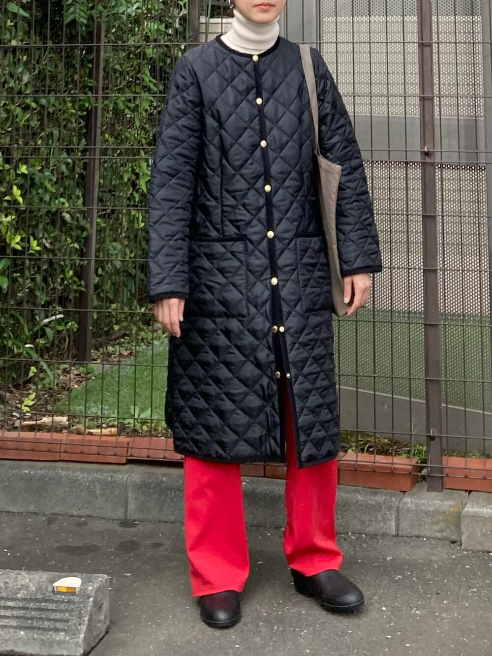 ブラック系のその他アウター、ブラウン系のトートバッグ、ブラック系のレインシューズを着用したレディースの秋コーディネートの2枚目の写真