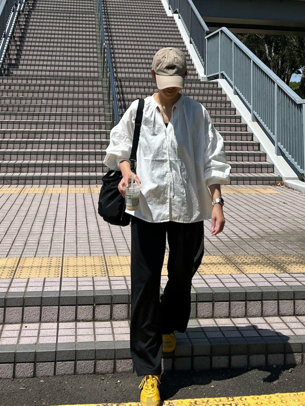 ブルー系のデニムジャケット、ホワイト系のシャツ/ブラウス、ブラック系のスラックスを着用したレディースの春コーディネートの5枚目の写真