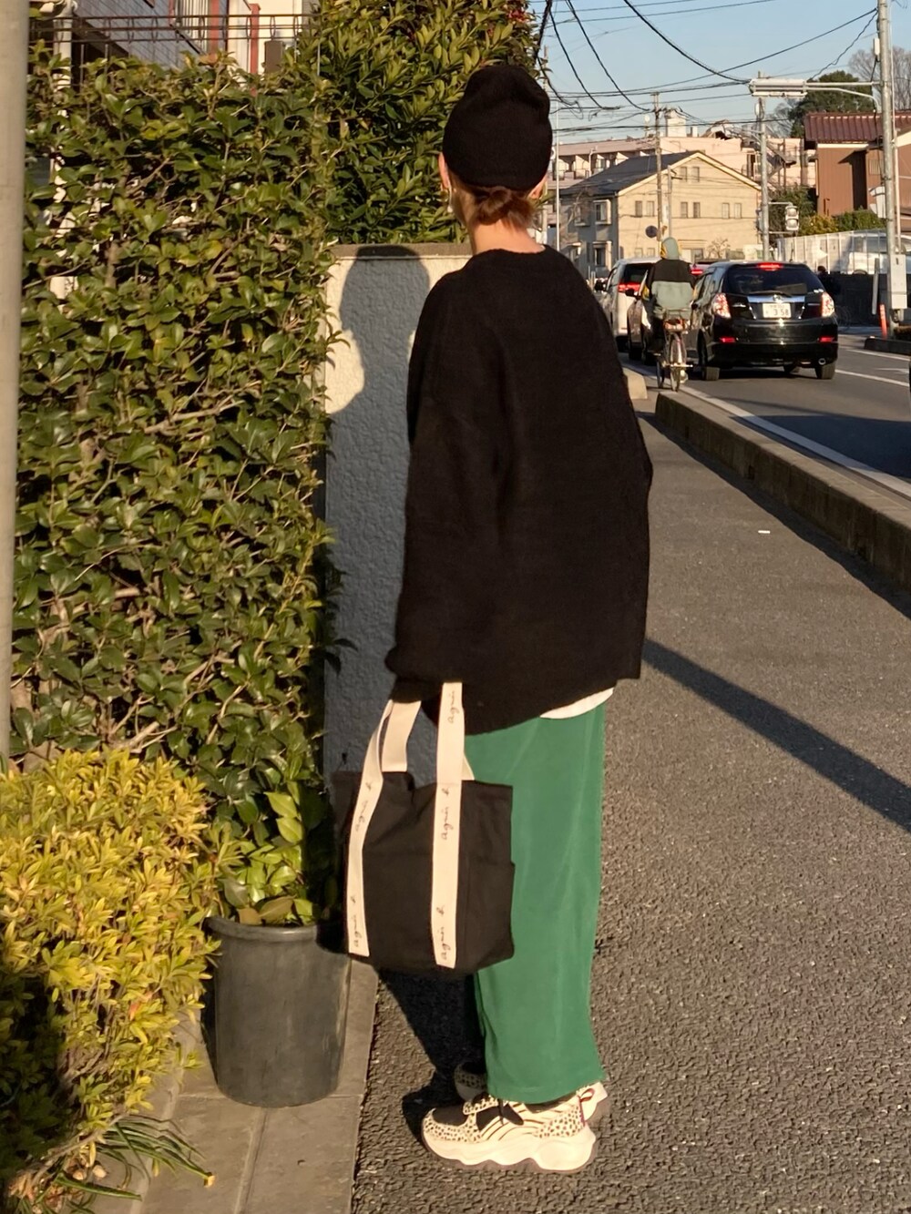 ブラック系のトートバッグ、ブラック系のニット/セーター、グリーン系のスカートを着用したレディースの冬コーディネートの2枚目の写真