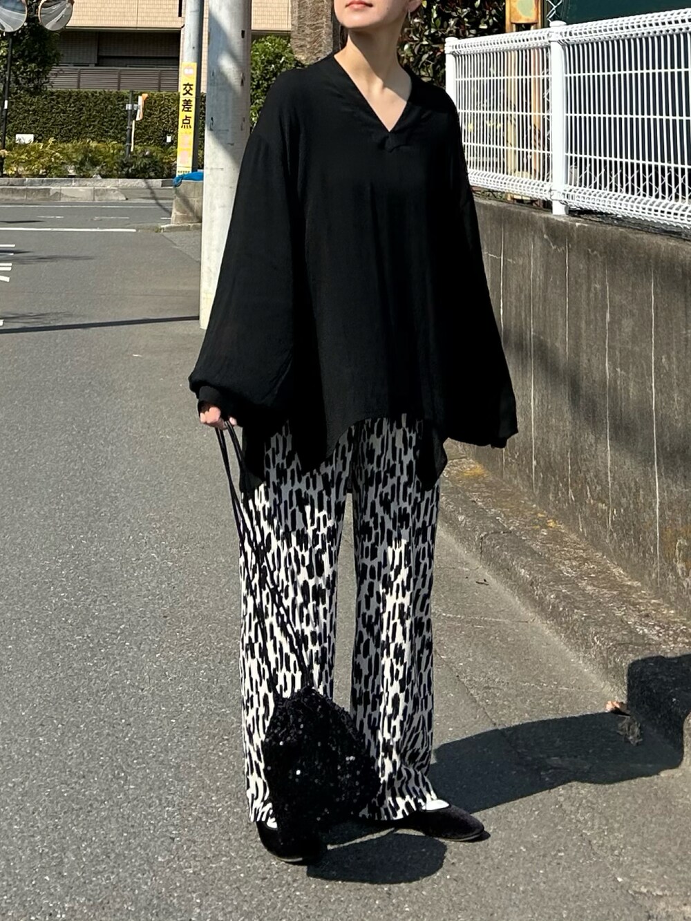 ブラック系のシャツ/ブラウス、ブラック系のショルダーバッグ、ホワイト系のその他パンツを着用したレディースの春コーディネートの3枚目の写真