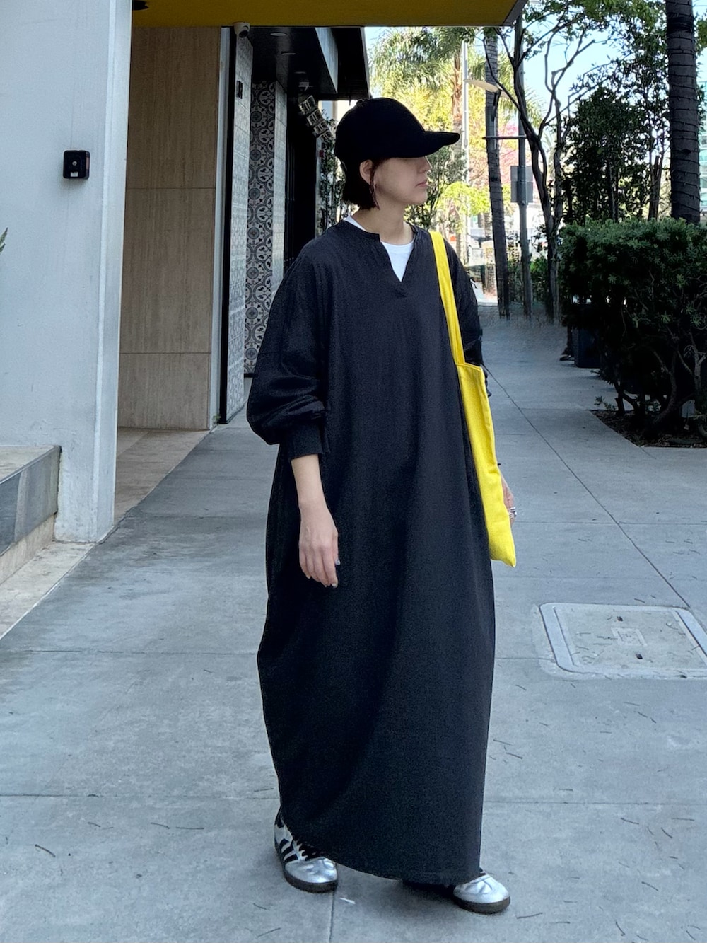 グレー系のワンピース、イエロー系のトートバッグ、シルバー系のスニーカーを着用したレディースの春コーディネートの4枚目の写真