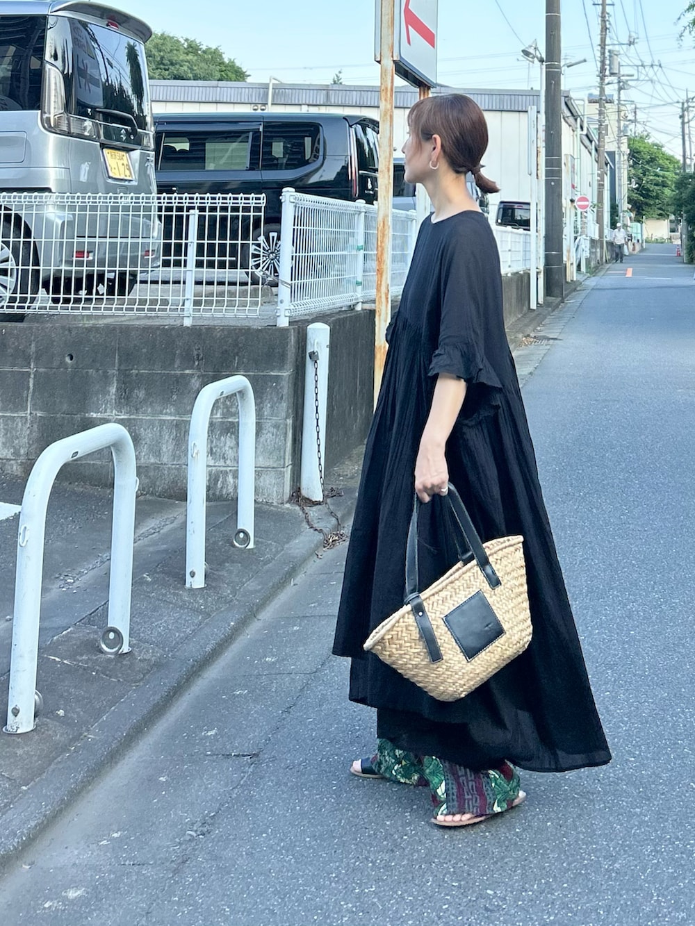 ブラック系のワンピース、ブラック系のかごバッグ、ブラック系のサンダルを着用したレディースの夏コーディネートの4枚目の写真