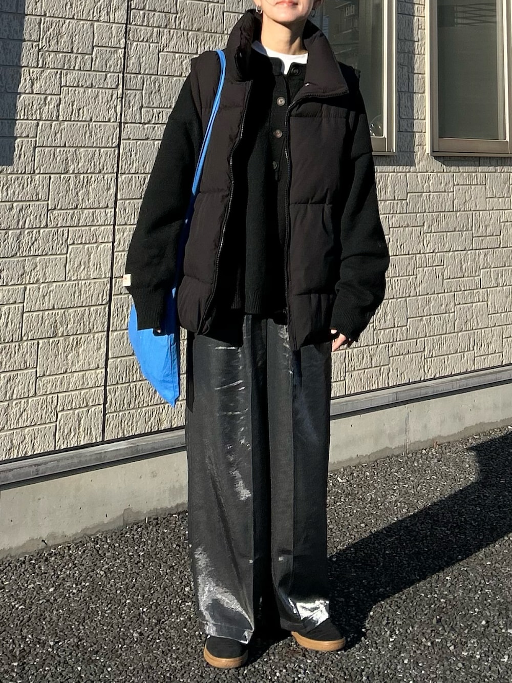 ブラック系のダウンベスト、ブラック系のその他パンツ、ブラック系のニット/セーターを着用したレディースの冬コーディネートの3枚目の写真