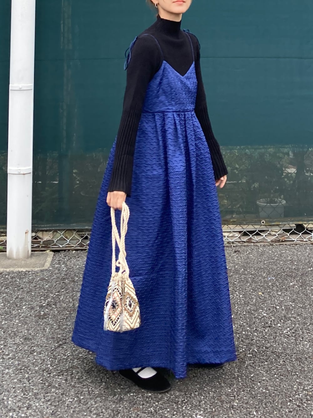 ブラック系のニット/セーター、ブルー系のワンピース、ブラック系のバレエシューズを着用したレディースの秋コーディネートの4枚目の写真