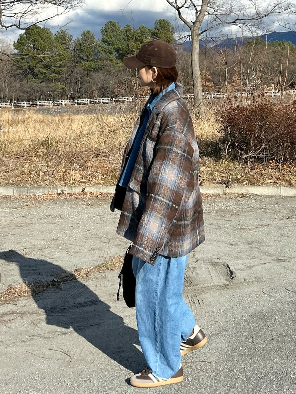 ブルー系のシャツ/ブラウス、ブルー系のデニムパンツ、ブラウン系のテーラードジャケットを着用したレディースの冬コーディネートの4枚目の写真